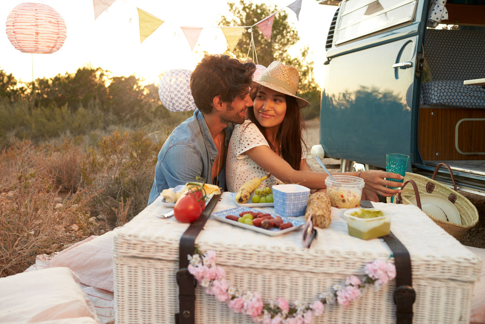 a couple sitting at table near their van in a huggin embrace